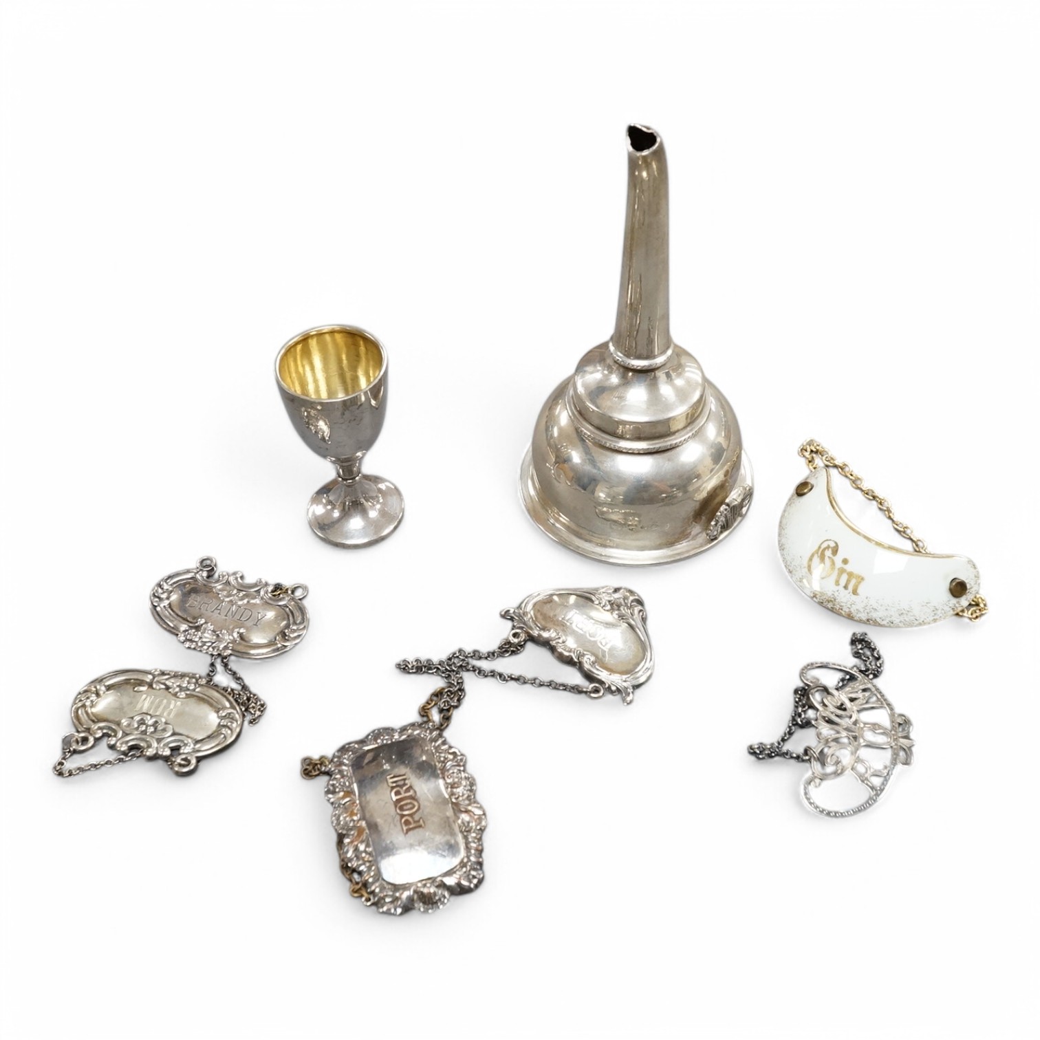 A modern silver wine funnel, with shell thumbpiece, L.J. Millington, Birmingham, 2000, 13.4cm, together with a small silver pedestal cup, three assorted sterling wine labels and three other wine labels including two plat